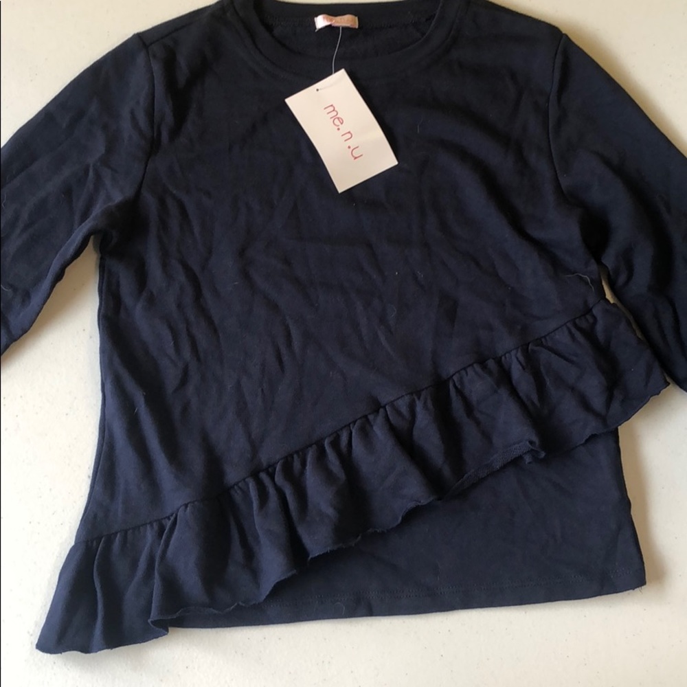 A navy sweater with ruffles down the bottom